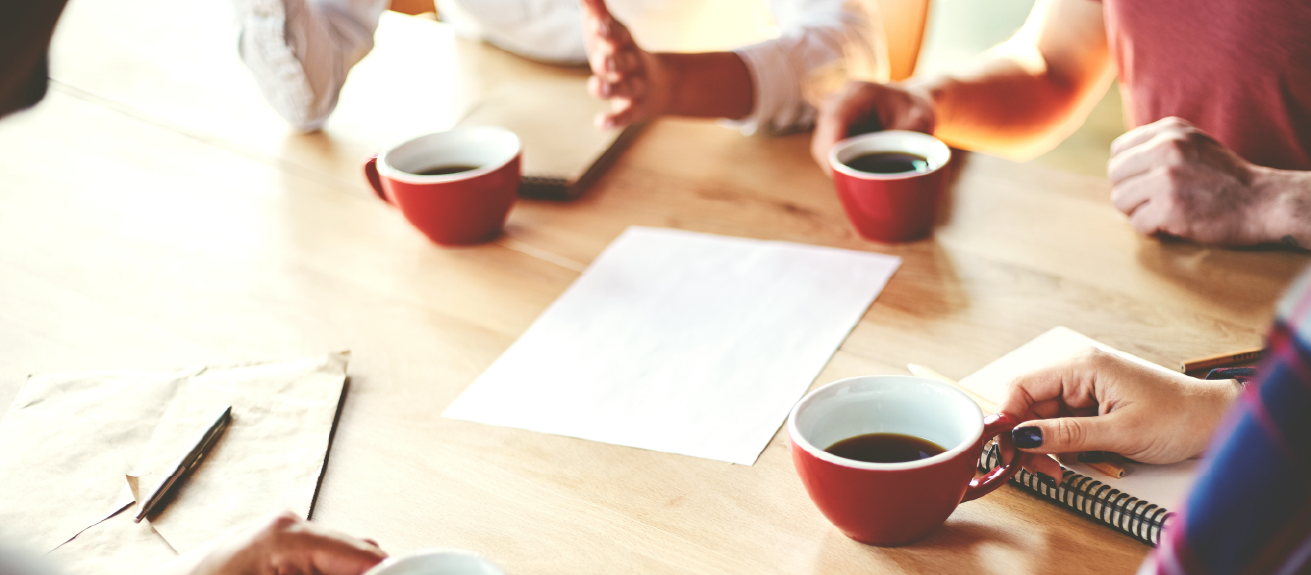 Photo of hands only around coffee table. You can tell people are in a discussion.