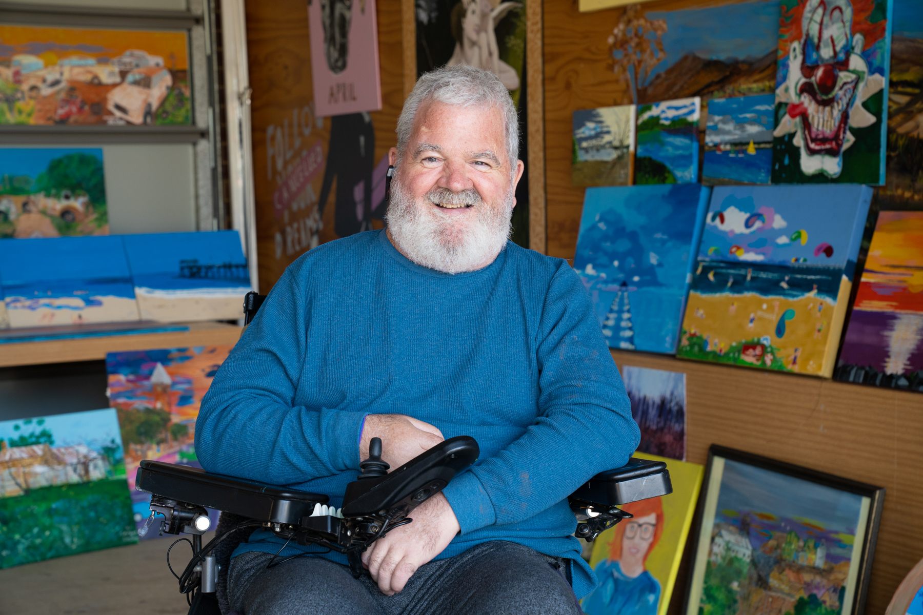 Photo of Rod with his paintings in the background.jpg