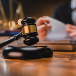 close up judge gavel with judge looking at documents in background
