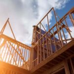 Photo shows the wooden frame of a house in the process of being built.