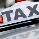Photo of a white Taxi sign.