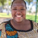 Photo of Esther, an African woman, smiling at camera.